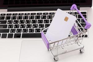 credit kaart in boodschappen doen kar Aan laptop toetsenbord. online boodschappen doen concept foto