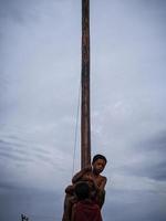 de opwinding van kinderen en volwassenen nemen een deel in de areca beklimming wedstrijd naar verlevendigen de onafhankelijkheid dag van de republiek van Indonesië, oosten- kalimantaan, Indonesië, augustus, 14,2022 foto