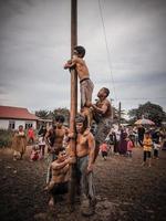 de opwinding van kinderen en volwassenen nemen een deel in de areca beklimming wedstrijd naar verlevendigen de onafhankelijkheid dag van de republiek van Indonesië, oosten- kalimantaan, Indonesië, augustus, 14,2022 foto