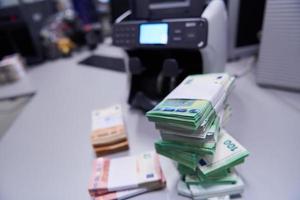 bankbiljetten in voorkant van elektronisch geld tellen machine foto