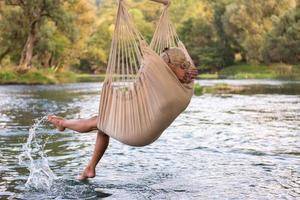 blond vrouw resting Aan hangmat foto