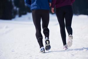 paar jogging buiten Aan sneeuw foto