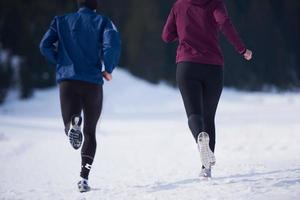 paar jogging buiten Aan sneeuw foto