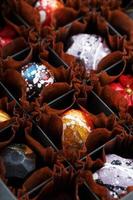kleurrijk handgemaakt chocolaatjes in een doos Aan een donker achtergrond foto