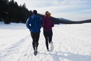 paar jogging buiten Aan sneeuw foto