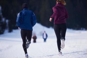 paar jogging buiten Aan sneeuw foto