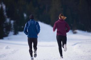 paar jogging buiten Aan sneeuw foto