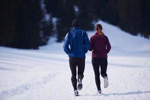 paar jogging buiten Aan sneeuw foto