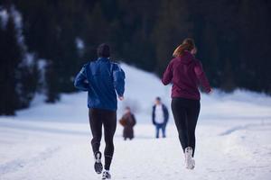 paar jogging buiten Aan sneeuw foto