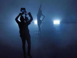 professioneel videograaf met gimball video slr opname video van vrouw atletisch danser in een donker milieu foto