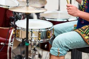 drummer man drummen percussie met stokken, drumstel op concertpodium, drumsticks en drums foto