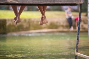 mensen zittend Bij houten brug foto