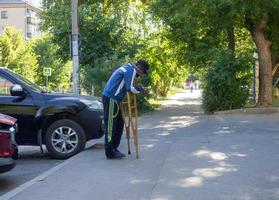 Kazan, Rusland. 18-06-2021 de arm Mens Aan krukken smeekt voor aalmoes. foto