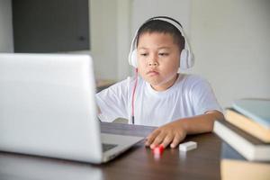 jong leerling afstand aan het leren virtueel afstand online klasse Aan video telefoontje virtueel les, technologie aan het studeren Bij huis gebruik makend van laptop computer. ouder of tutor onderwijs kind jongen met afgelegen onderwijs. foto