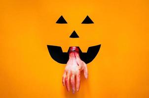 halloween pompoen gezicht achtergrond met gesneden hand- Aan zwart en oranje papier. minimaal halloween concept. foto