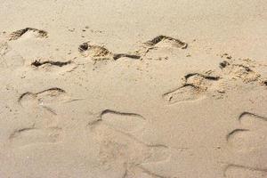 voet prints Aan een zanderig strand foto