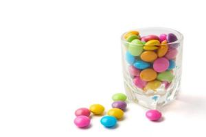 kleurrijk snoepjes in glas Aan wit achtergrond, vrij ruimte voor tekst. foto