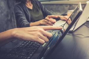 bedrijf partners werken samen Aan de dezelfde bureau, ze zijn gebruik makend van een laptop, wijnoogst toon foto