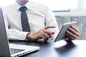 zakenman gebruik makend van tablet en laptop Aan de bureau. foto