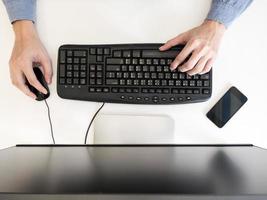 top visie van mannetje handen werken Aan computer Aan de bureau. foto