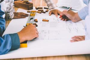 team van ingenieurs bespreken architectuur plan schetsen Bij de bouw plaats. foto