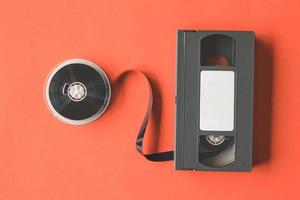 video cassette plakband en haspel Aan oranje achtergrond. foto