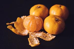 dichtbij omhoog van vers mandarijnen, oranje fruit Aan donker achtergrond. foto