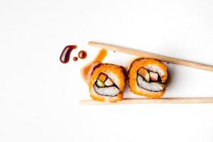 sushi, Japans voedsel, Californië rollen met eetstokjes en saus Aan wit achtergrond. foto