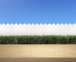 houten tafel terras met, wit houten hek en groen struik Aan een Doorzichtig blauw lucht achtergrond foto