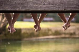 mensen zittend Bij houten brug foto