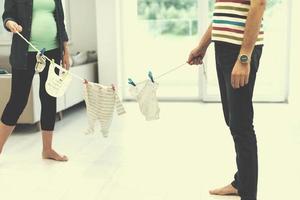 jong paar Holding baby bodysuits Bij huis foto