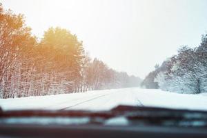 visie van auto Aan besneeuwd winter weg foto