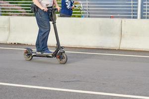 dichtbij omhoog van Mens het rijden Aan elektrisch scooter in de stad foto