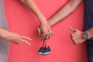 jong zwanger paar Holding pasgeboren baby schoenen foto