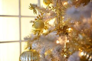 goud Kerstmis decoraties Aan een wit kunstmatig net dichtbij - omhoog. feestelijk achtergrond, nieuw jaar. venster met geel licht. ruimte voor tekst foto