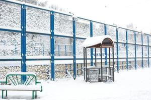 met sneeuw bedekt binnenplaats van een woon- kwartaal hoog hek sport- basketbal rechtbank, bank, Prieel. winter sneeuw atmosfeer foto