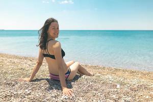 het meisje ligt te zonnebaden op het strand foto