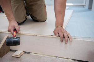 professionele werknemer die nieuwe gelamineerde houten vloer installeert foto