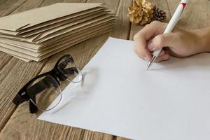 hand- Holding pen met papier Aan houten tafel foto