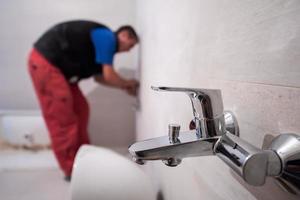 professioneel loodgieter werken in een badkamer foto