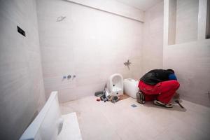 professioneel loodgieter werken in een badkamer foto