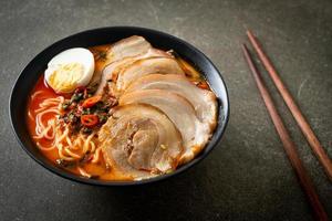 ramen noodles pittige tomyum soep met geroosterd varkensvlees foto