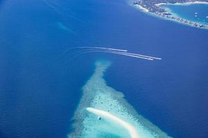 antenne afbeelding van turkoois blauw tropisch oceaan lagune, wit zanderig strand, zandbank koraal rif Ondiep water met een boot. natuur perfectie in Maldiven zee. luxe leven beleven, vredig landschap foto