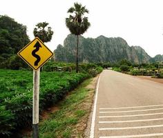 lang weg dat reizen door divers dorp in landelijk Thailand voorbijgaan door Woud weiden en berg Aan Doorzichtig dag blauw lucht wit wolk in zomer geschikt het rijden foto