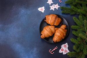 krokant chocola croissant met Kerstmis decoraties Aan donker tafel foto