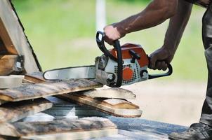 hout arbeider met kettingsjaa detailopname foto
