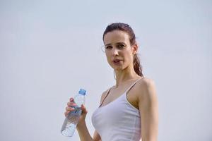 jonge mooie vrouw drinkwater na fitness oefening foto