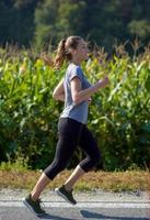 vrouw joggen langs een landweg foto