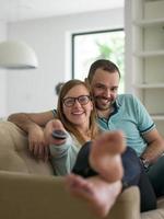 jong koppel op de bank televisie kijken foto