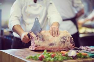 chef snijdend groot stuk van rundvlees foto